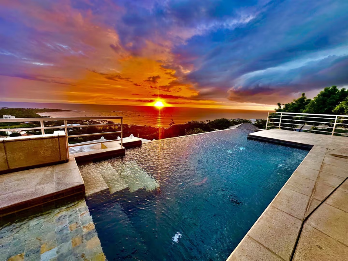 Piscina infinita de la villa al atardecer