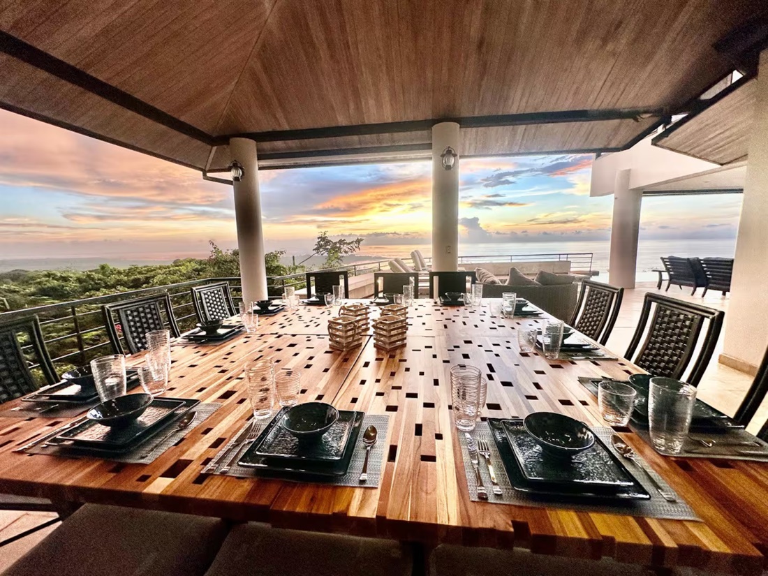 Mesa preparada para cenar con vista al atardecer